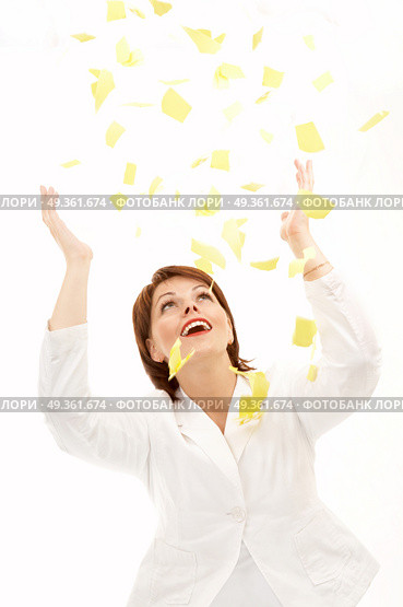The beautiful woman throws above a head yellow scraps of a paper on a white background. Good-bye paper work! Стоковое фото, агентство Ingram Publishing / Фотобанк Лори