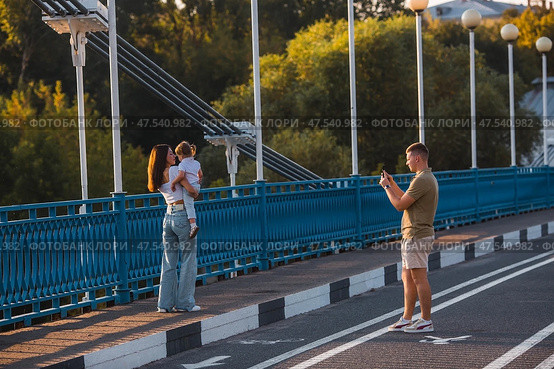The bridge over the Kotorosl River to Damansky Island and people passing by. Yaroslavl, Russia. Редакционное фото, фотограф Photojuli / Фотобанк Лори