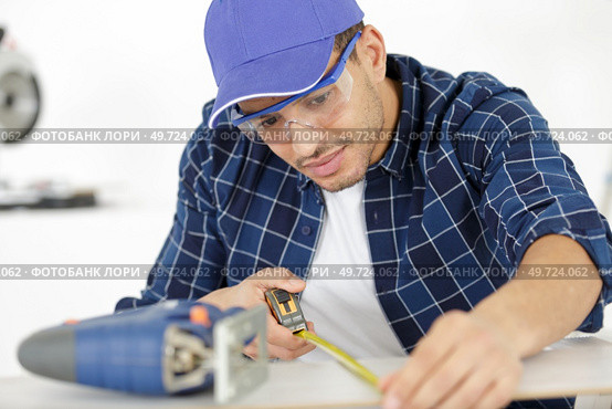 the builder worker measures something. Стоковое фото, агентство Ingram Publishing / Фотобанк Лори