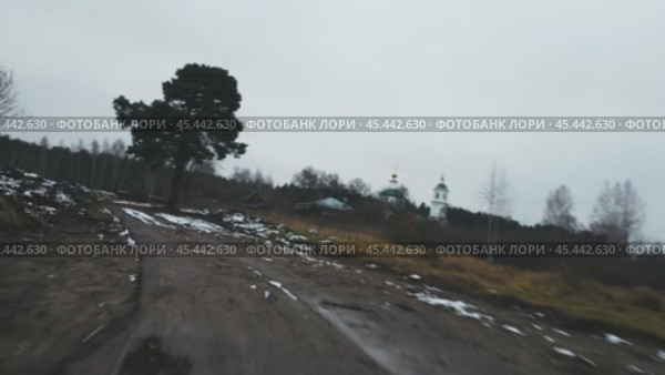 The camera flies at a fast speed over a broken dirty rural country road dusted with the first snow. Aerial photography from a drone. Стоковое видео, видеограф Ярославский Максим / Фотобанк Лори
