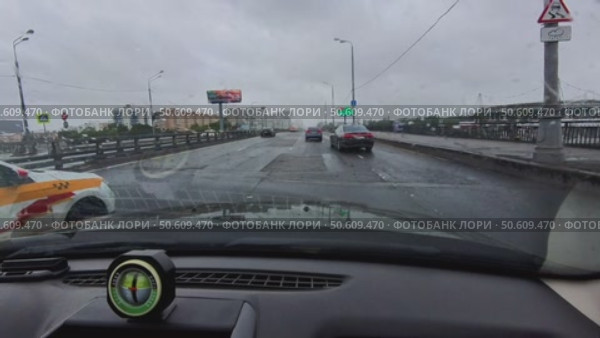 The car is driving along the highway, and a bridge is visible to the right of the car. Russia. Moscow. 30.06.25. Стоковое видео, видеограф Ярославский Максим / Фотобанк Лори