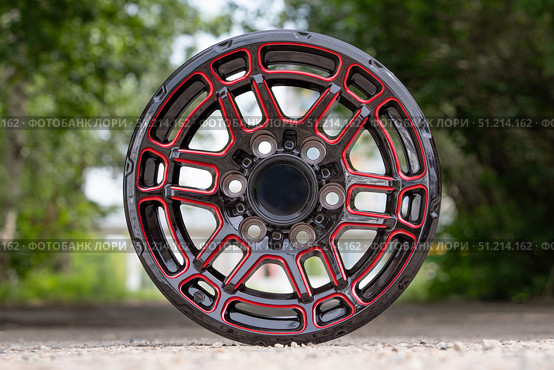 The cast disc is new from the SUV, black with red elements, auto parts wheel front view on the street. Стоковое фото, фотограф Владимир Разгуляев / Фотобанк Лори