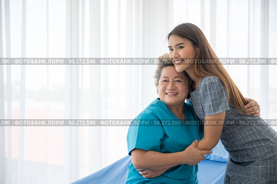 The daughter visits the grandmother who is sick in the hospital. Стоковое фото, агентство Ingram Publishing / Фотобанк Лори