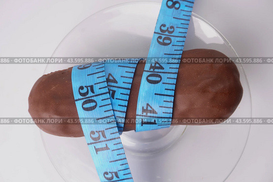 The eclair cake is wrapped with measuring tape. Стоковое фото, фотограф Ярославский Максим / Фотобанк Лори