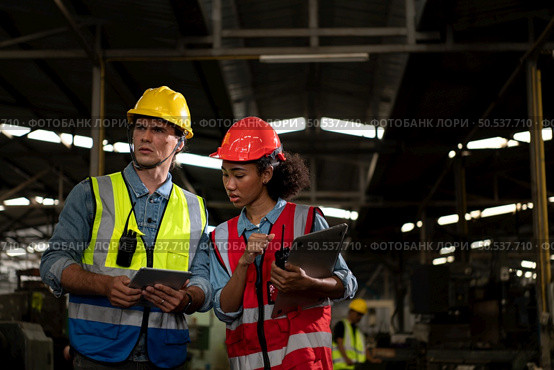 The foreign chief engineer came to inspect the old mechanical factory. There is an African female mechanic explaining details and progress reports on old machines being repaired to restore normal operation. Стоковое фото, агентство Ingram Publishing / Фотобанк Лори