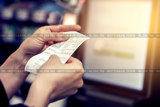 The girl looks at the receipt in the store. Стоковое фото, фотограф Владимир Разгуляев / Фотобанк Лори