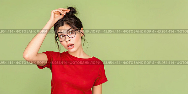 The girl with glasses remembered an old problem and thought about it. She keeps her hand on her head. Copy space. Стоковое AI-изображение, AI-художник Ярославский Максим / Фотобанк Лори