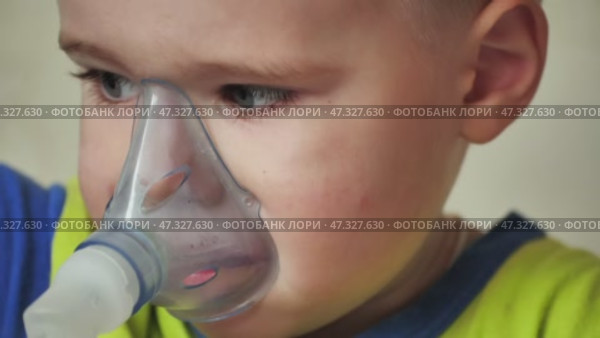 The kid breathes in a mask with an inhaler. Стоковое видео, видеограф Mikhail Davidovich / Фотобанк Лори