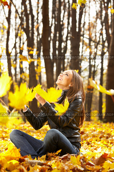 The laughing girl throws autumn leaves in park. Seasons. Стоковое фото, агентство Ingram Publishing / Фотобанк Лори