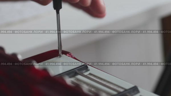 The man fasten with screws the right cover of the button accordion. Bayan repair and maintenance. Close-up. Стоковое видео, видеограф Vadzim Yakubovich / Фотобанк Лори