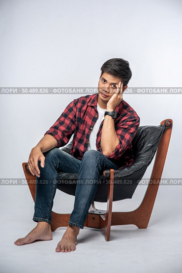The man was sick, sat on a chair, and touched her head with her hand. Стоковое фото, агентство Ingram Publishing / Фотобанк Лори