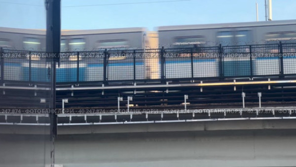 The Moscow metro train passes through the metro bridge between the administrative buildings. Sokolniki district Moscow.28.03.2023. Редакционное видео, видеограф Ярославский Максим / Фотобанк Лори