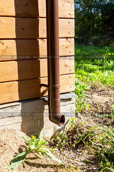 The new plastic rainwater drain pipe on a wooden house. Стоковое фото, фотограф FotograFF / Фотобанк Лори