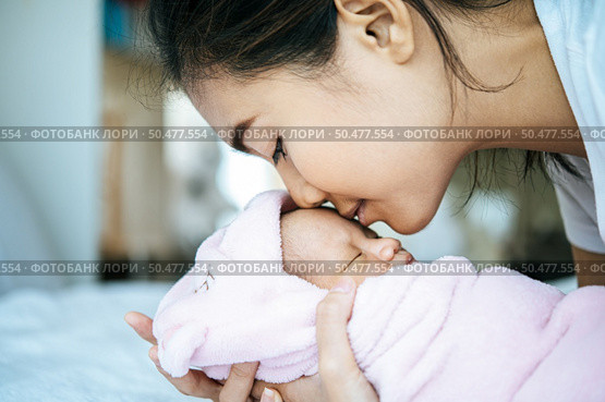 The newborn baby sleeping in the mother’s arms and fragrant on the baby’s forehead. Стоковое фото, агентство Ingram Publishing / Фотобанк Лори