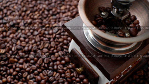 The process of pouring whole coffee beans into the manual grinder. A scattering of coffee beans. View from above. Стоковое видео, видеограф Алексей Гекало / Фотобанк Лори