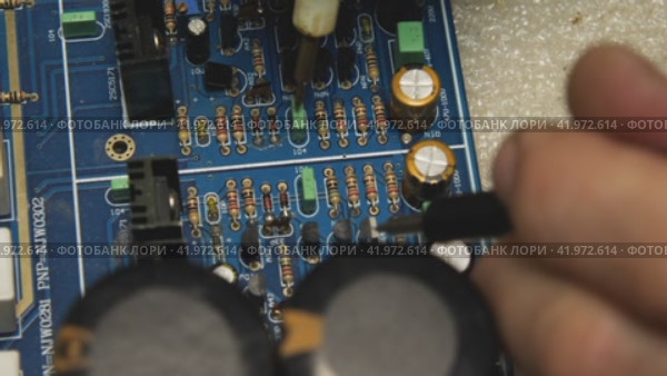 The repairman uses a tester to check the pins on the blue motherboard. Repair shop for electronics, computers, phones and TV. Стоковое видео, видеограф Воловодов Владимир / Фотобанк Лори