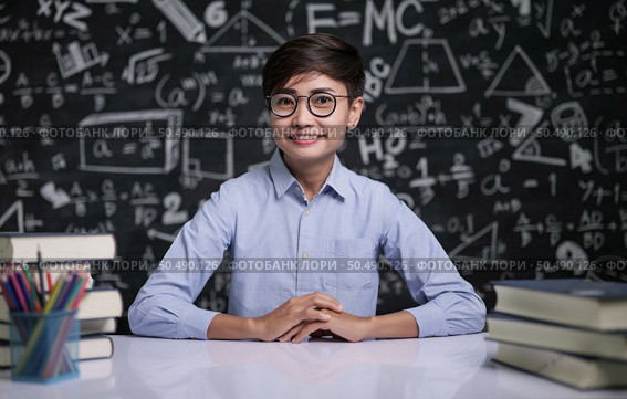 The teacher sat at the table to teach the students in the classroom. Стоковое фото, агентство Ingram Publishing / Фотобанк Лори