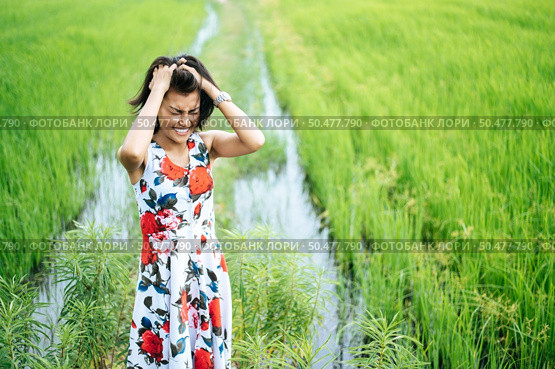 The woman stood tense and the hand held her hair in the meadow. Стоковое фото, агентство Ingram Publishing / Фотобанк Лори