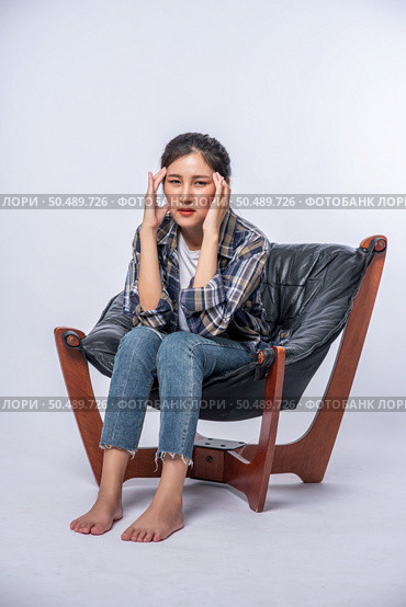 The woman was sick, sat on a chair, and touched her head with her hand. Стоковое фото, агентство Ingram Publishing / Фотобанк Лори