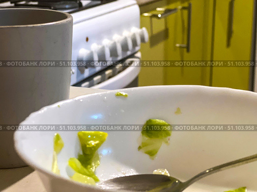 There is a bowl of leftover food on the table with a spoon in it. Стоковое фото, фотограф Ярославский Максим / Фотобанк Лори