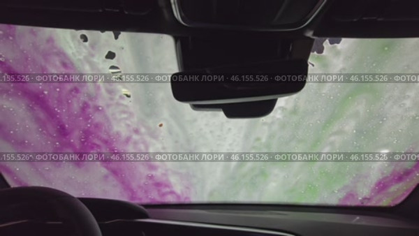 Thick foam, which abundantly covers whole car. Camera focuses on how foam slowly spreads along hood, roof and side sides of car. You can see how she envelops every detail. Стоковое видео, видеограф Скрипачев Антон / Фотобанк Лори