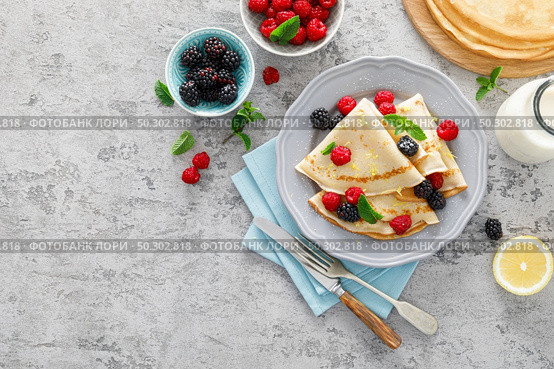 Thin crepes with fresh berries and lemon zest. Pancakes with raspberry and blackberry. Стоковое фото, агентство Ingram Publishing / Фотобанк Лори