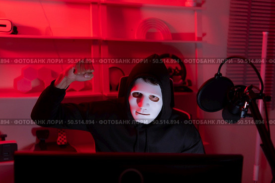 This is the face of a hacker who is knowledgeable with operating systems and other programs. He will exploit flaws and breach the computer system to cause damage. Стоковое фото, агентство Ingram Publishing / Фотобанк Лори