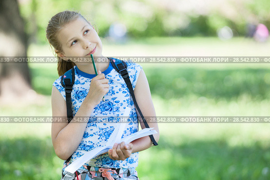Thoughtful girl with colored pencil in her mouth looks at landscape she wants to paint, copy space. Стоковое фото, фотограф Кекяляйнен Андрей / Фотобанк Лори