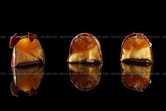 three multi-colored candies in the context of on a black background. section of delicious chocolates candies. Стоковое фото, агентство Ingram Publishing / Фотобанк Лори