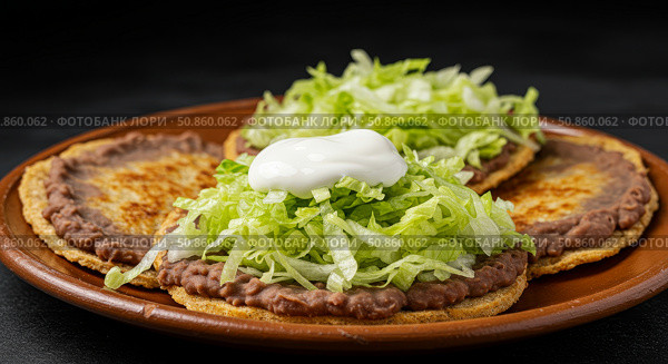 Three traditional Mexican sopes with refried beans, lettuce, and sour cream on a terracotta plate. Authentic latin american street food for menu design. Стоковое AI-изображение, AI-художник Анжелика Самсонова / Фотобанк Лори