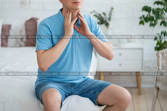 Thyroid gland inflammation, sore throat and cough, man with neck pain on gray background. Стоковое фото, фотограф Станислав Тарко / Фотобанк Лори