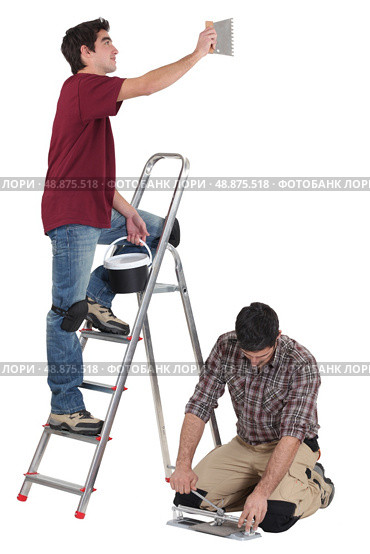 tiler and apprentice working together. Стоковое фото, агентство Ingram Publishing / Фотобанк Лори