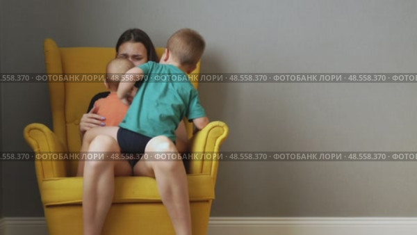 tired exhausted young mother sitting disturb in chair with two naughty children. Стоковое видео, видеограф Olesia Kondrateva / Фотобанк Лори