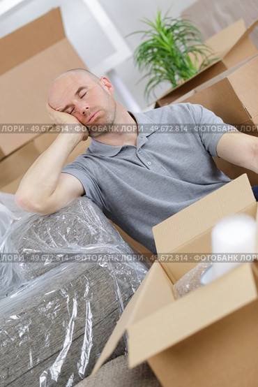 tired young man napping on couch in new house. Стоковое фото, агентство Ingram Publishing / Фотобанк Лори
