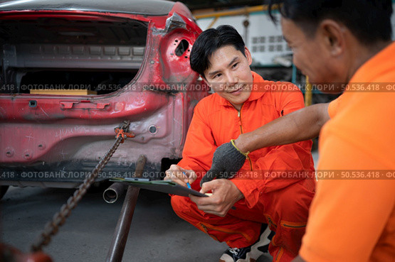 To return the automobile body to its former shape, an auto repair mechanic uses a machine to pull the car body caused by a heavy collision until it is deformed. Стоковое фото, агентство Ingram Publishing / Фотобанк Лори