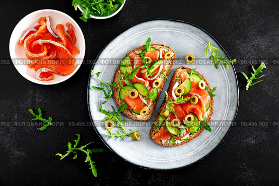 Toasts with salted salmon, arugula, green olives and cucumber, top down view. Стоковое фото, агентство Ingram Publishing / Фотобанк Лори
