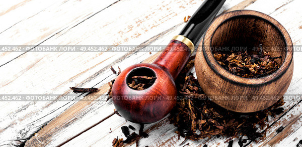 Tobacco pipe or smoking pipe on a wooden table. Smoking pipe on a wooden table. Стоковое фото, агентство Ingram Publishing / Фотобанк Лори