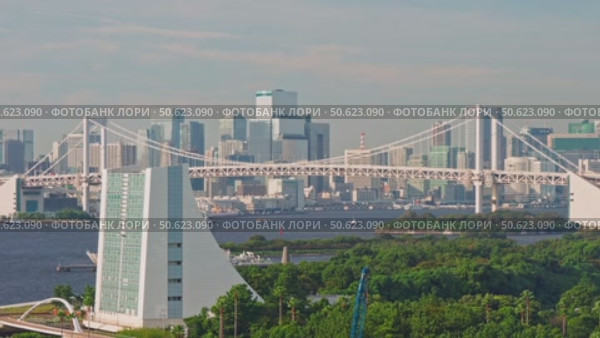 Tokyo, Japan - Oct 2 2024, 4k, panoramic aerial view of Tokyo Bay cityscape in background and the Rainbow Bridge, in the foreground is a part of Odaiba Island with a triangular building, Tokyo, Japan. Стоковое видео, видеограф Сергей Богомяко / Фотобанк Лори