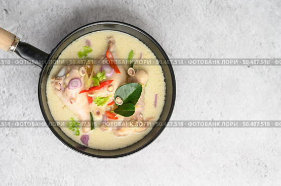 Tom Kha Kai in a pan frying with kaffir lime leaves, lemongrass, red onion, galangal and chilli. Top view. Стоковое фото, агентство Ingram Publishing / Фотобанк Лори