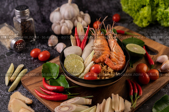 Tom Yum Kung in a bowl with tomato, chili, lemongrass, garlic, lemon, and kaffir lime leaves. Стоковое фото, агентство Ingram Publishing / Фотобанк Лори
