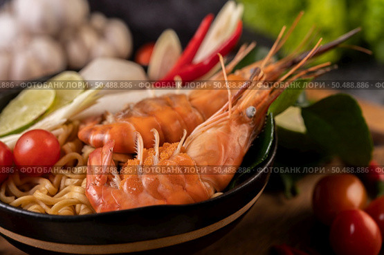 Tom Yum Kung in a bowl with tomato, chili, lemongrass, garlic, lemon, and kaffir lime leaves. Стоковое фото, агентство Ingram Publishing / Фотобанк Лори