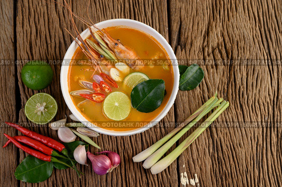Tom Yum Kung Thai hot spicy soup shrimp with lemon grass,lemon,galangal and chilli on wooden background Thailand Food. Стоковое фото, агентство Ingram Publishing / Фотобанк Лори