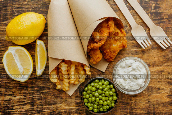 top view fish chips paper wrap with peas cutlery. Стоковое фото, агентство Ingram Publishing / Фотобанк Лори
