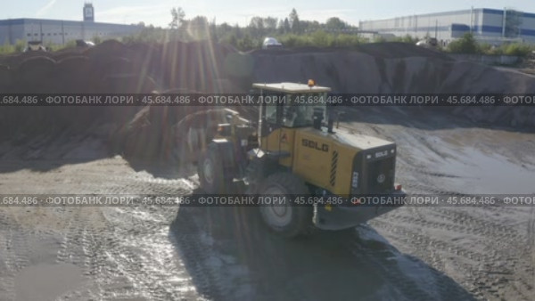 Top view of a sand quarry with a bulldozer working with concrete. Редакционное видео, видеограф Николай Титюк / Фотобанк Лори