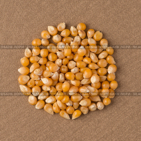 Top view of circle of corn against brown vinyl background. Стоковое фото, агентство Ingram Publishing / Фотобанк Лори