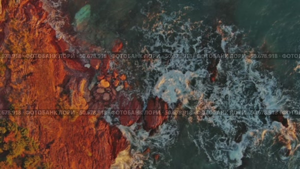 Top view of waves and red rocks in sea. Стоковое видео, видеограф Михаил Коханчиков / Фотобанк Лори
