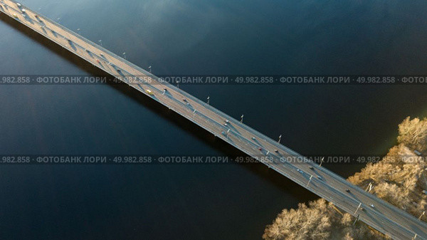 Top view on the Dnieper River and the North Bridge with passing cars on a spring day Kiev, Ukraine. Drone photography. Kiev, Ukraine view from above on the North Bridge with passing cars through the Dnieper River, photo from the drone. Стоковое фото, агентство Ingram Publishing / Фотобанк Лори