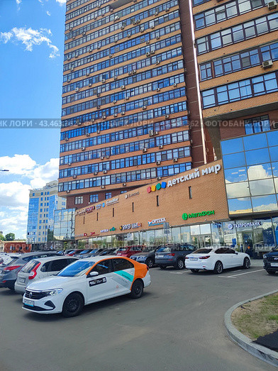Торговый центр с парковкой в Москве, каршеринговый делимобиль на парковке (2024 год). Редакционное фото, фотограф Ирина Терентьева / Фотобанк Лори