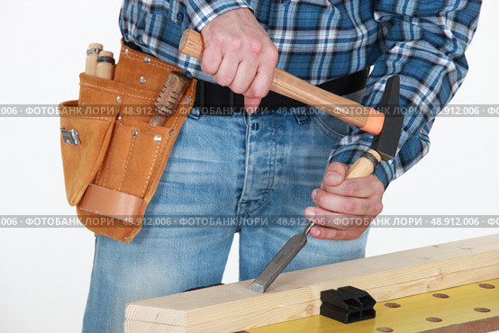 Tradesman chiseling a plank of wood. Стоковое фото, агентство Ingram Publishing / Фотобанк Лори