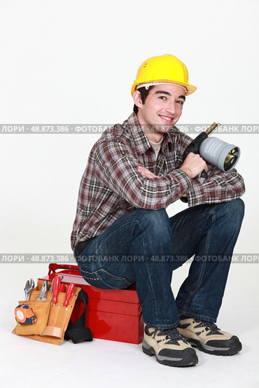 Tradesman holding a blowtorch and sitting on his toolbox. Стоковое фото, агентство Ingram Publishing / Фотобанк Лори